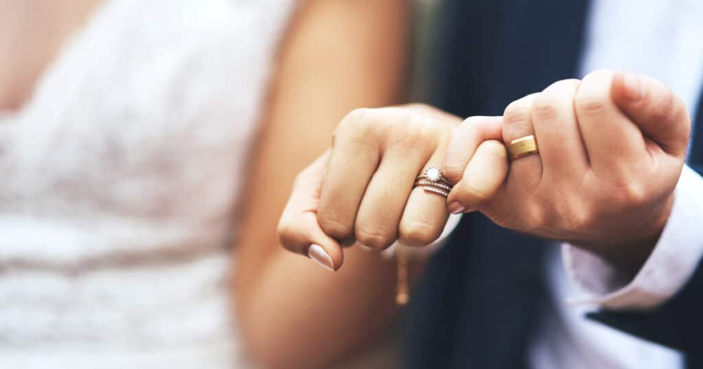 Newlywed couple making a pinky promise, representing marriage and a commitment to protect each other with life insurance coverage