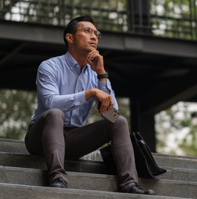 Thoughtful professional sitting on outdoor steps with a briefcase while considering next steps after leaving Federal service.