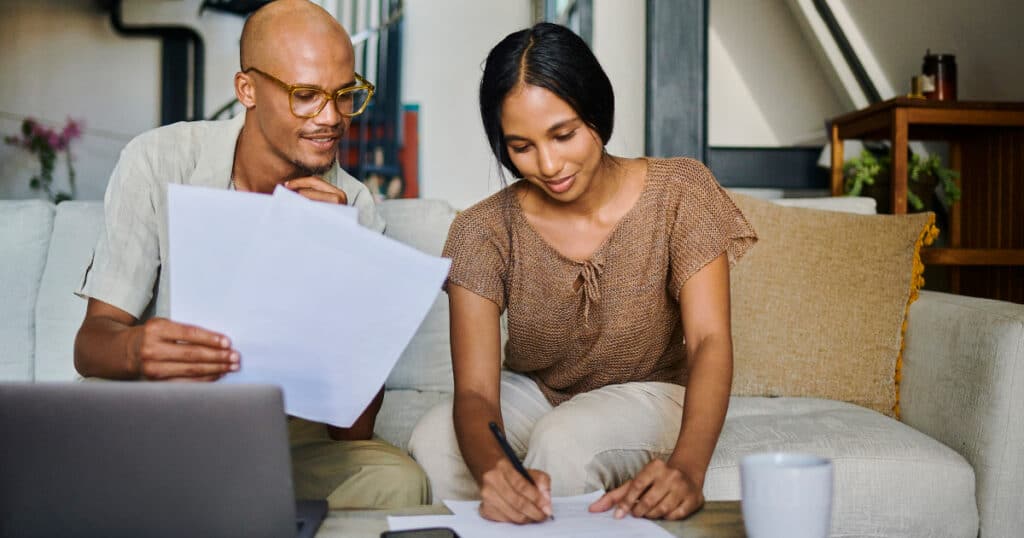 Couple reviewing estate plan and financial paperwork at home, representing estate planning and financial planning after a qualifying life event