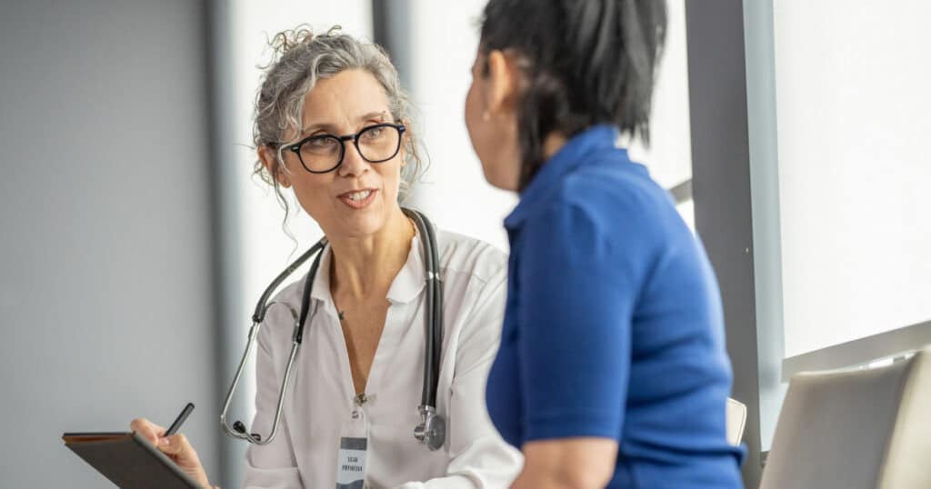 Doctor consulting with patient during a medical appointment, representing preventive care and health checkups after a qualifying life event