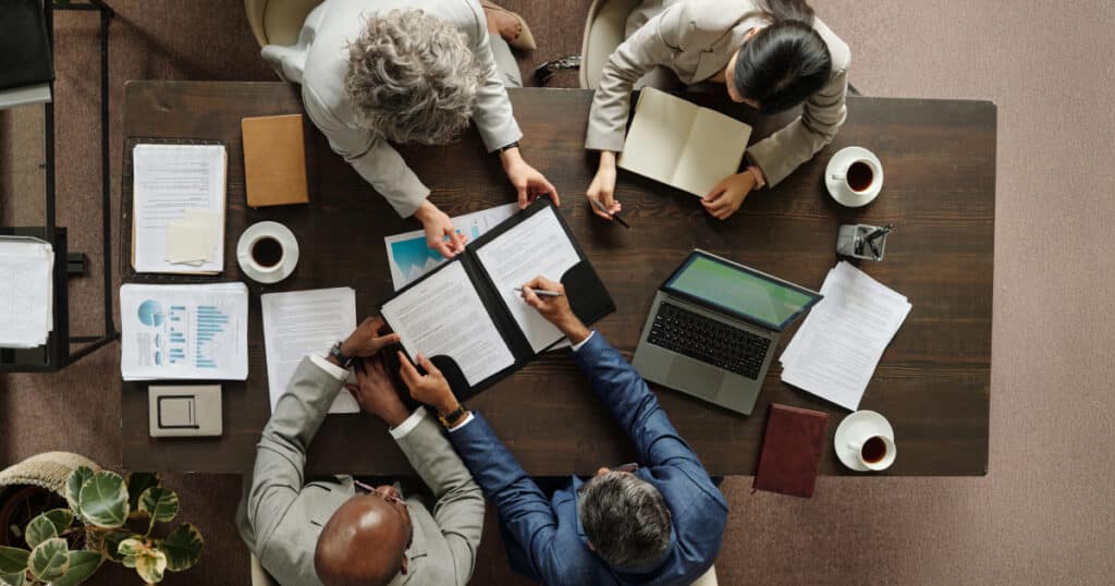 Federal employees reviewing financial and insurance documents together while discussing long-term coverage and benefits options.