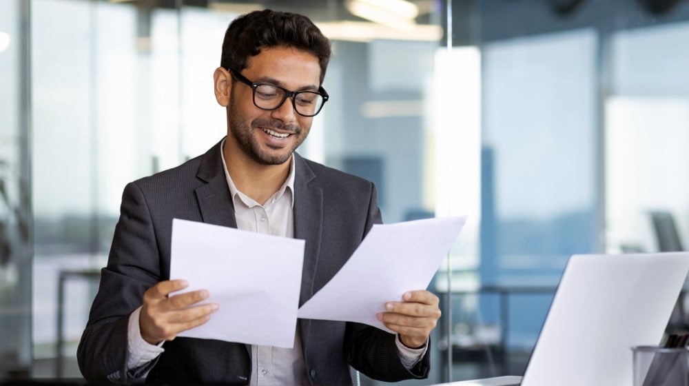Federal employee reviewing life insurance and financial planning documents.