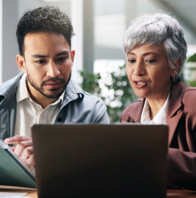 Employees discussing finances and reviewing disability paperwork together at a table.