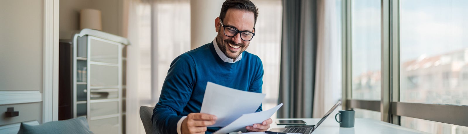 Professional reviewing financial documents at a desk, representing retirement planning, life insurance decisions, and long-term financial planning for Federal employees.