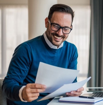 Professional reviewing financial documents at a desk, representing retirement planning, life insurance decisions, and long-term financial planning for Federal employees.